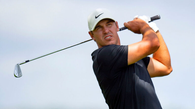 England Football Squad Plays Golf with Top Golfer Brooks Koepka swings to strike the ball during the 3M Open on the ninth hole
