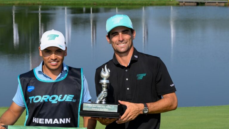 First place Individual Champion, Captain Joaquín Niemann of Torque GC and caddie, Diego Salinas, pose for a photo with the trophy after the final round of LIV Golf New York at Trump National Golf Club